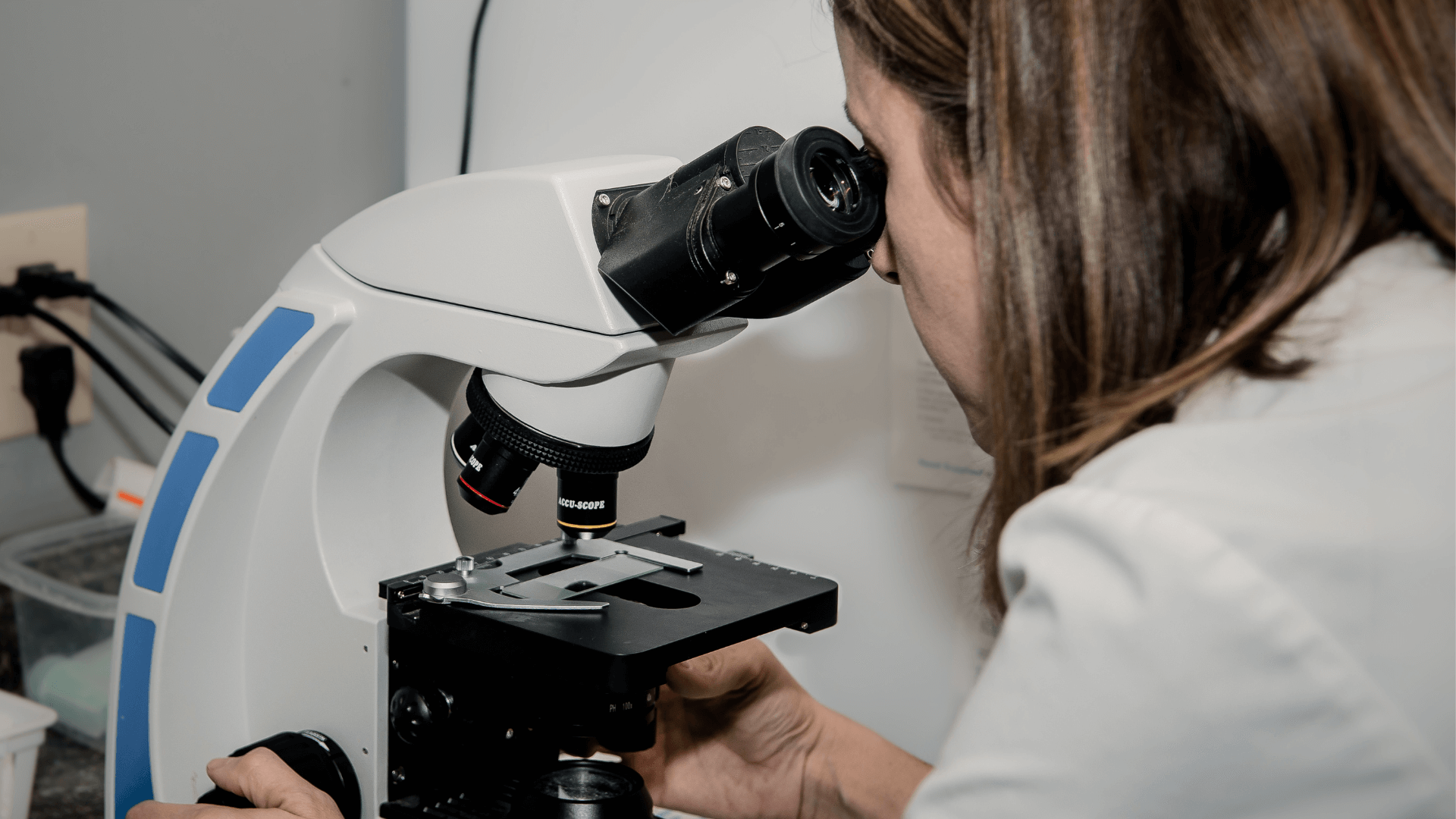 woman looking at microscope